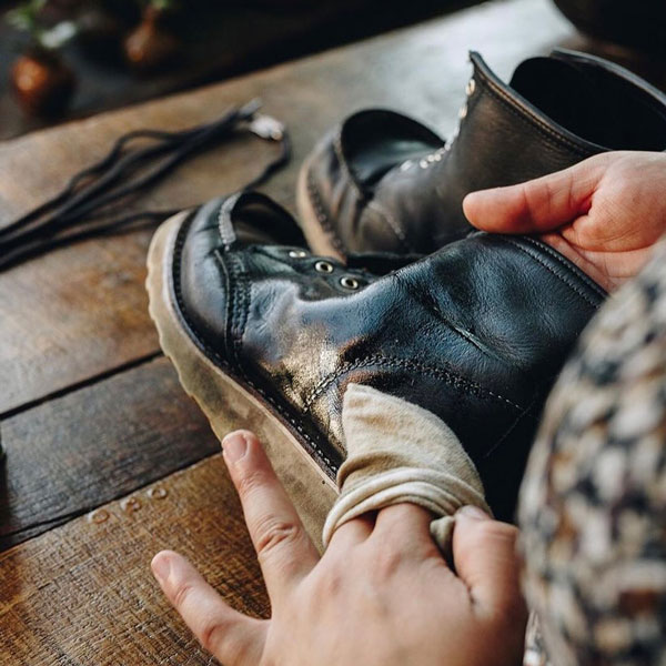 woman oiling a black boot