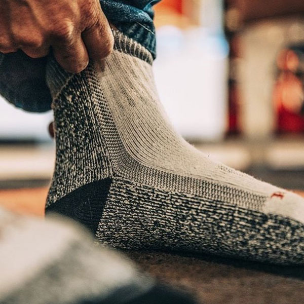 man pulling up Red Wing brand sock