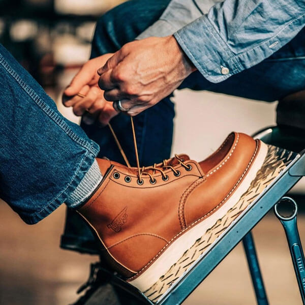 staff member assisting a customer with the perfect fit for their boot